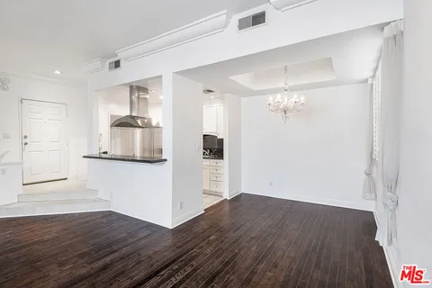 a view of a kitchen with wooden floor and a refrigerator