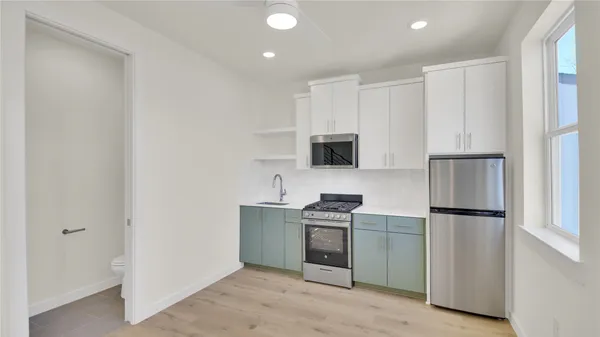 a kitchen with stainless steel appliances a refrigerator stove microwave and sink