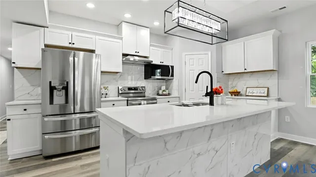 a kitchen with stainless steel appliances a refrigerator sink and cabinets