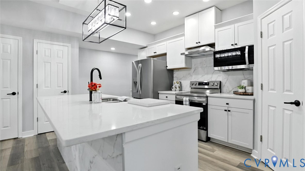 409 Mistletoe Street Petersburg, VA 23803 - Photo 14 of 40 a kitchen with stainless steel appliances kitchen island a white cabinets and refrigerator