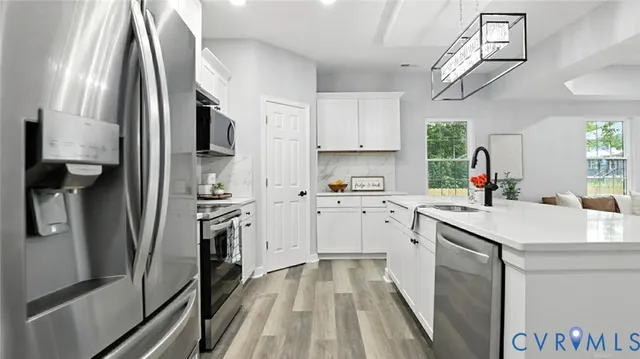 a kitchen with white cabinets and stainless steel appliances