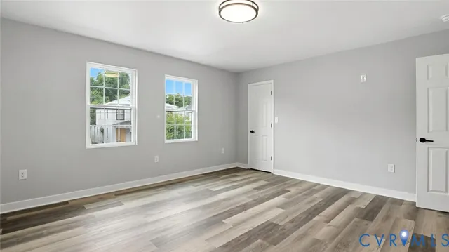 a view of a room with wooden floor and window