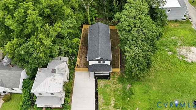 an aerial view of a house with a yard and large tree