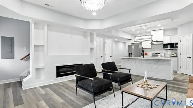 a living room with fireplace furniture and a hard wood floor