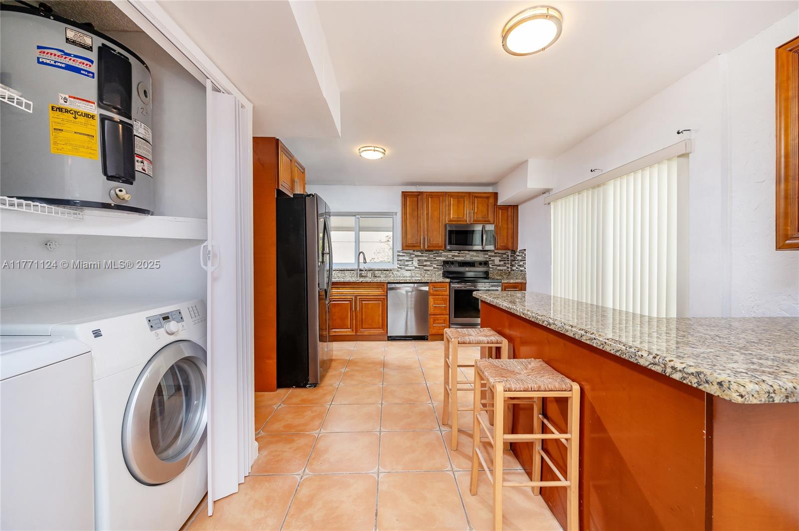 1007 Northwest 106th Ave Circle Miami, FL 33172 - Photo 13 of 41 a kitchen with stainless steel appliances granite countertop a sink a stove a refrigerator cabinets and a dining table