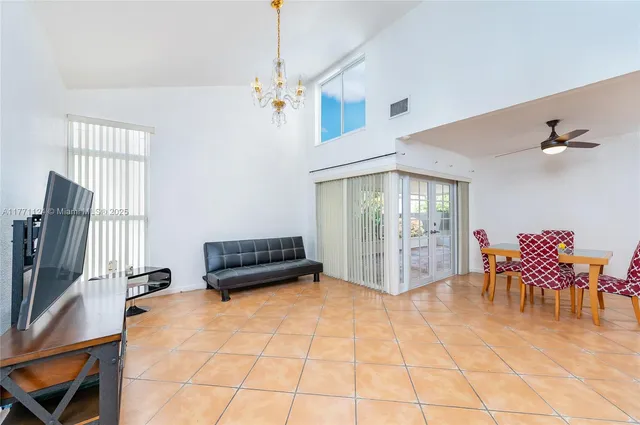 a living room with furniture a dining table and a chandelier