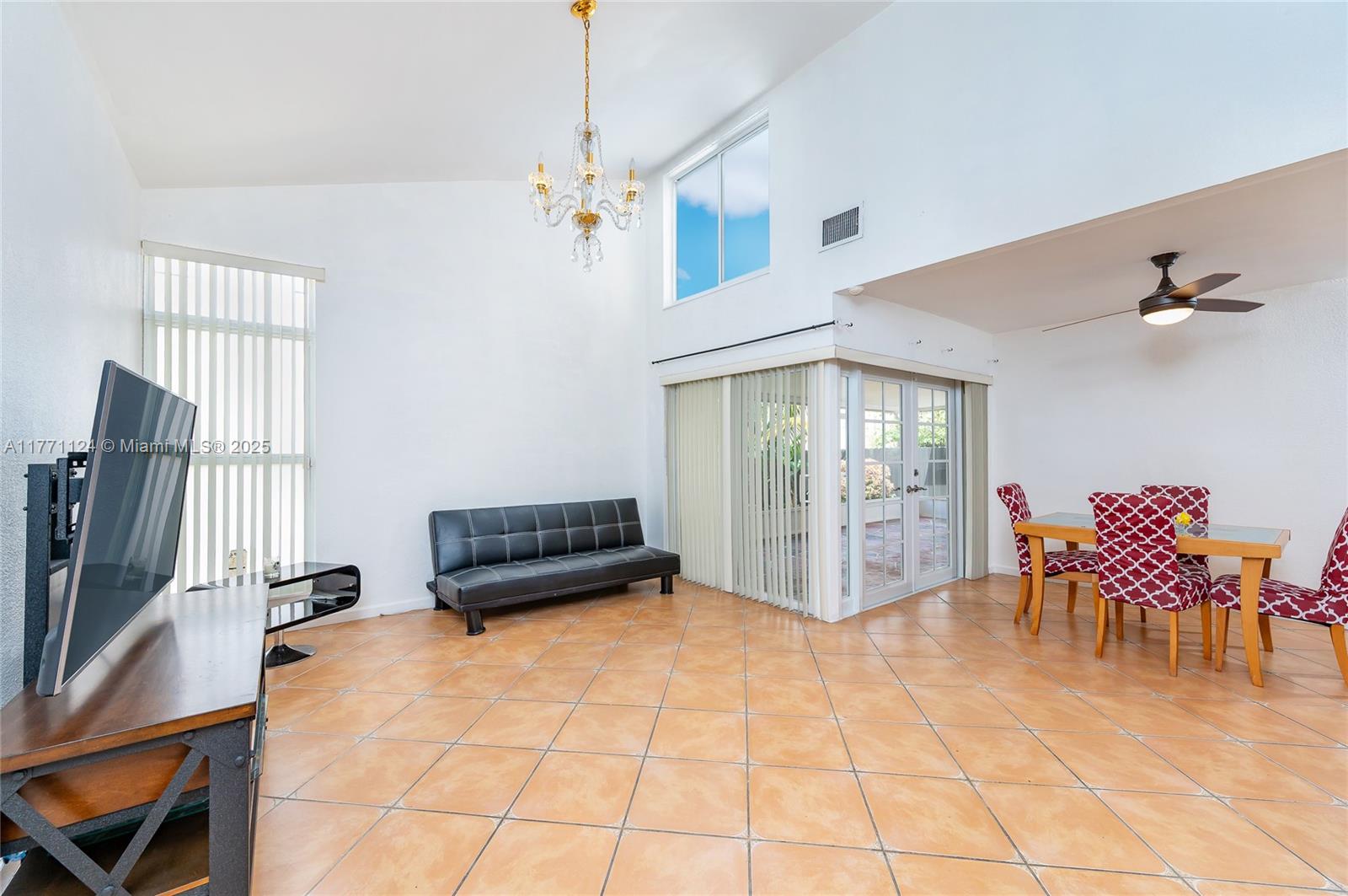 1007 Northwest 106th Ave Circle Miami, FL 33172 - Photo 4 of 41 a living room with furniture a dining table and a chandelier
