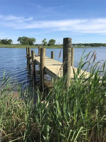a view of a balcony with table and chairs and wooden fence