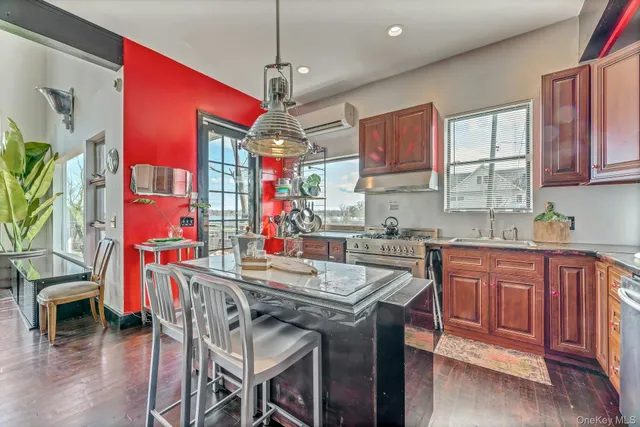 a kitchen with stainless steel appliances granite countertop wooden cabinets a dining table and chairs