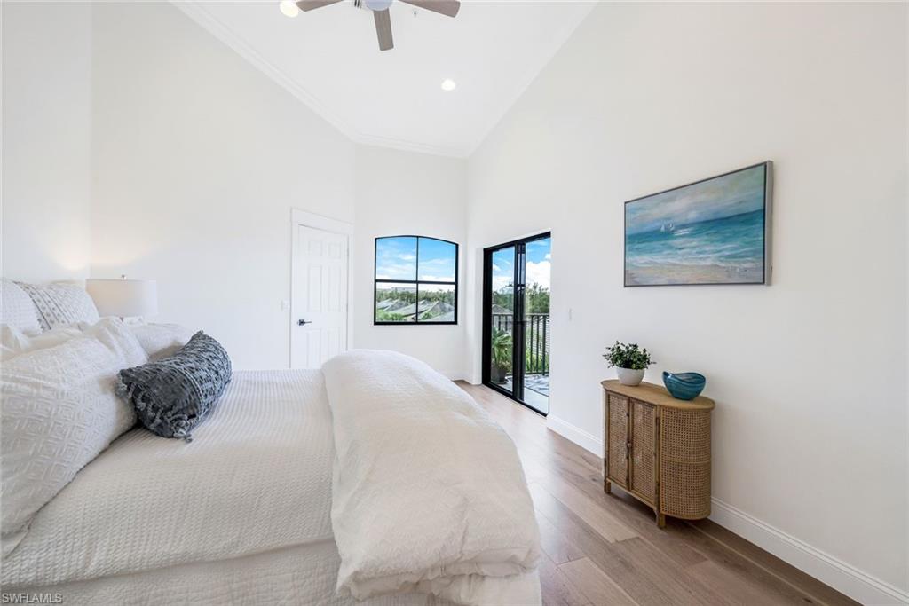 195 Vintage Circle, Unit E403 Naples, FL 34119 - Photo 15 of 39 a bedroom with a large bed and a window