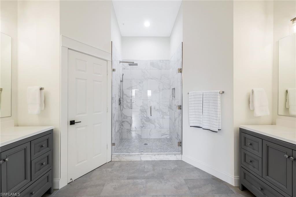195 Vintage Circle, Unit E403 Naples, FL 34119 - Photo 16 of 39 a bathroom with a shower sink and mirror