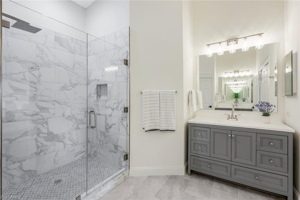 195 Vintage Circle, Unit E403 Naples, FL 34119 - Photo 17 of 39 a bathroom with a double vanity sink a toilet and shower