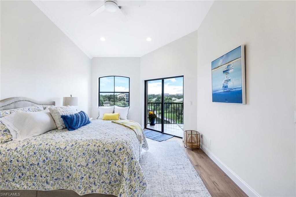 195 Vintage Circle, Unit E403 Naples, FL 34119 - Photo 18 of 39 a bedroom with a large bed and a large window