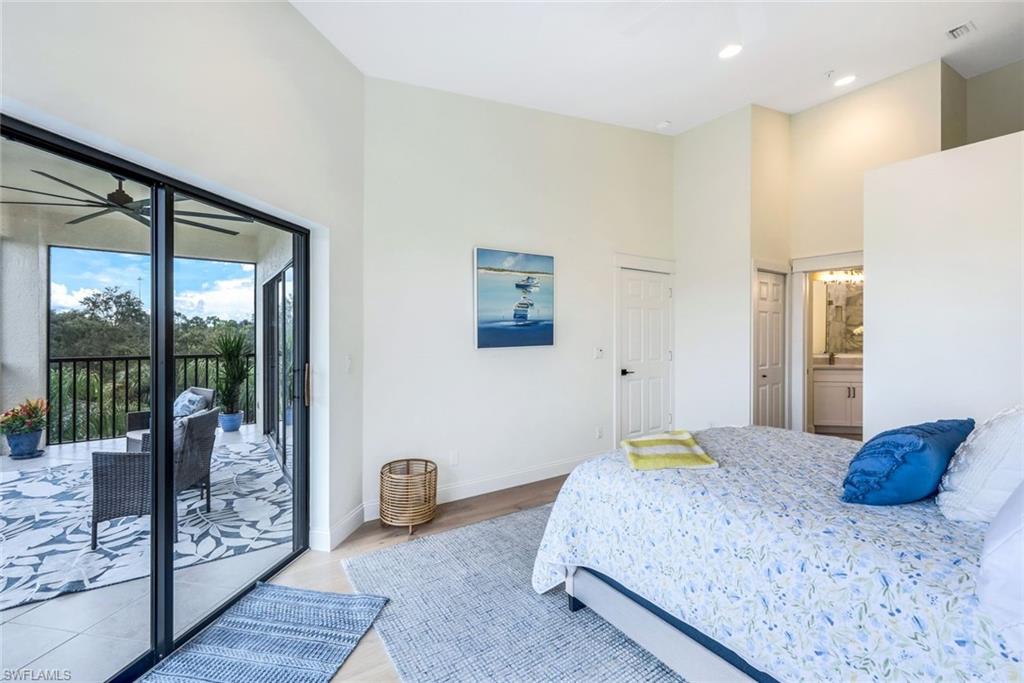 195 Vintage Circle, Unit E403 Naples, FL 34119 - Photo 20 of 39 a bedroom with a balcony a bed and a large window