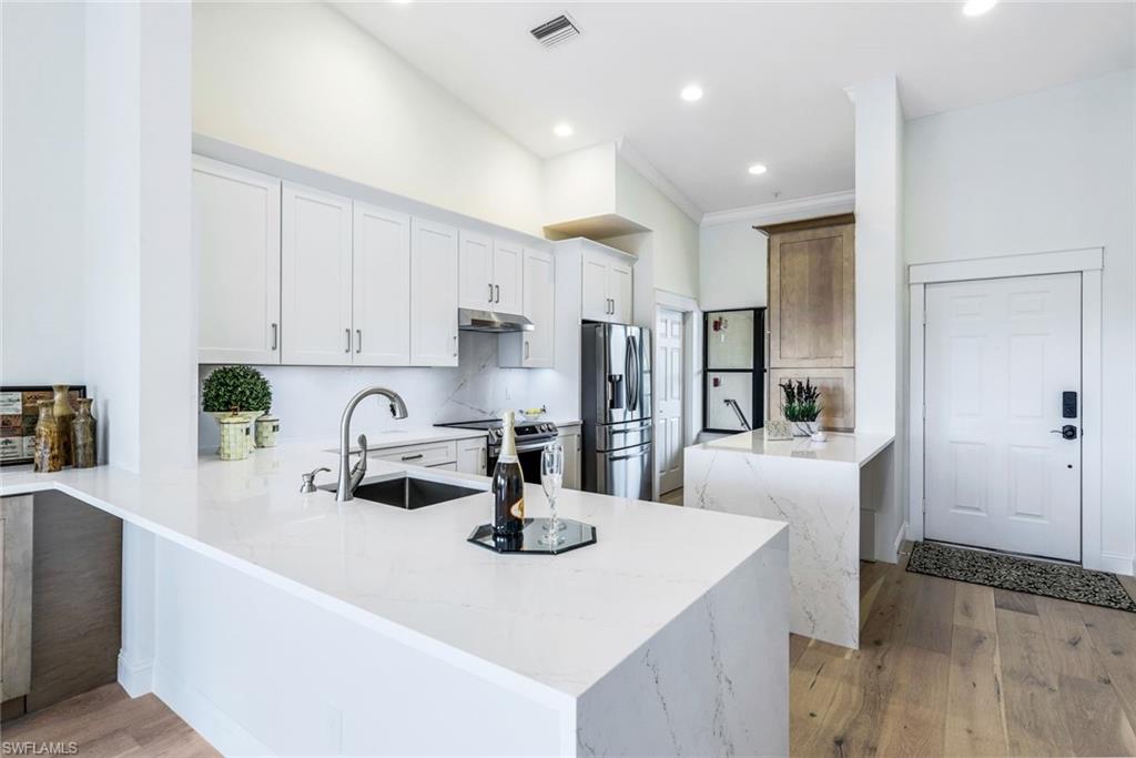 195 Vintage Circle, Unit E403 Naples, FL 34119 - Photo 2 of 39 a kitchen with kitchen island a sink stove and refrigerator