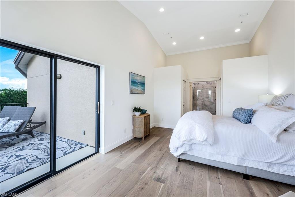 195 Vintage Circle, Unit E403 Naples, FL 34119 - Photo 21 of 39 a bedroom with a bed and wooden floor