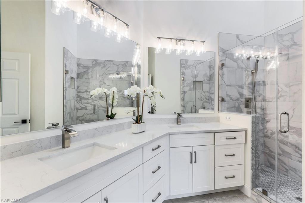195 Vintage Circle, Unit E403 Naples, FL 34119 - Photo 22 of 39 a bathroom with a double vanity sink mirror and double