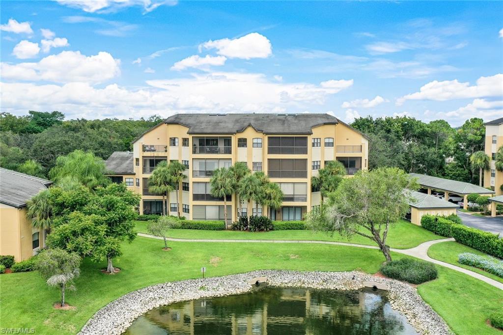 195 Vintage Circle, Unit E403 Naples, FL 34119 - Photo 29 of 39 a front view of a house with a yard