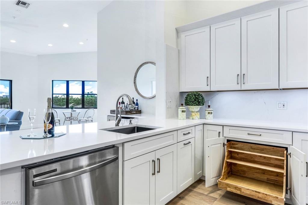 195 Vintage Circle, Unit E403 Naples, FL 34119 - Photo 5 of 39 a kitchen with appliances a sink and cabinets