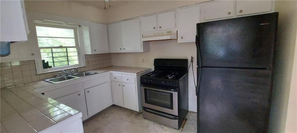 2980 Wanda Circle Southwest Atlanta, GA 30315 - Photo 6 of 11 a kitchen with stainless steel appliances granite countertop a refrigerator a sink a stove and white cabinets