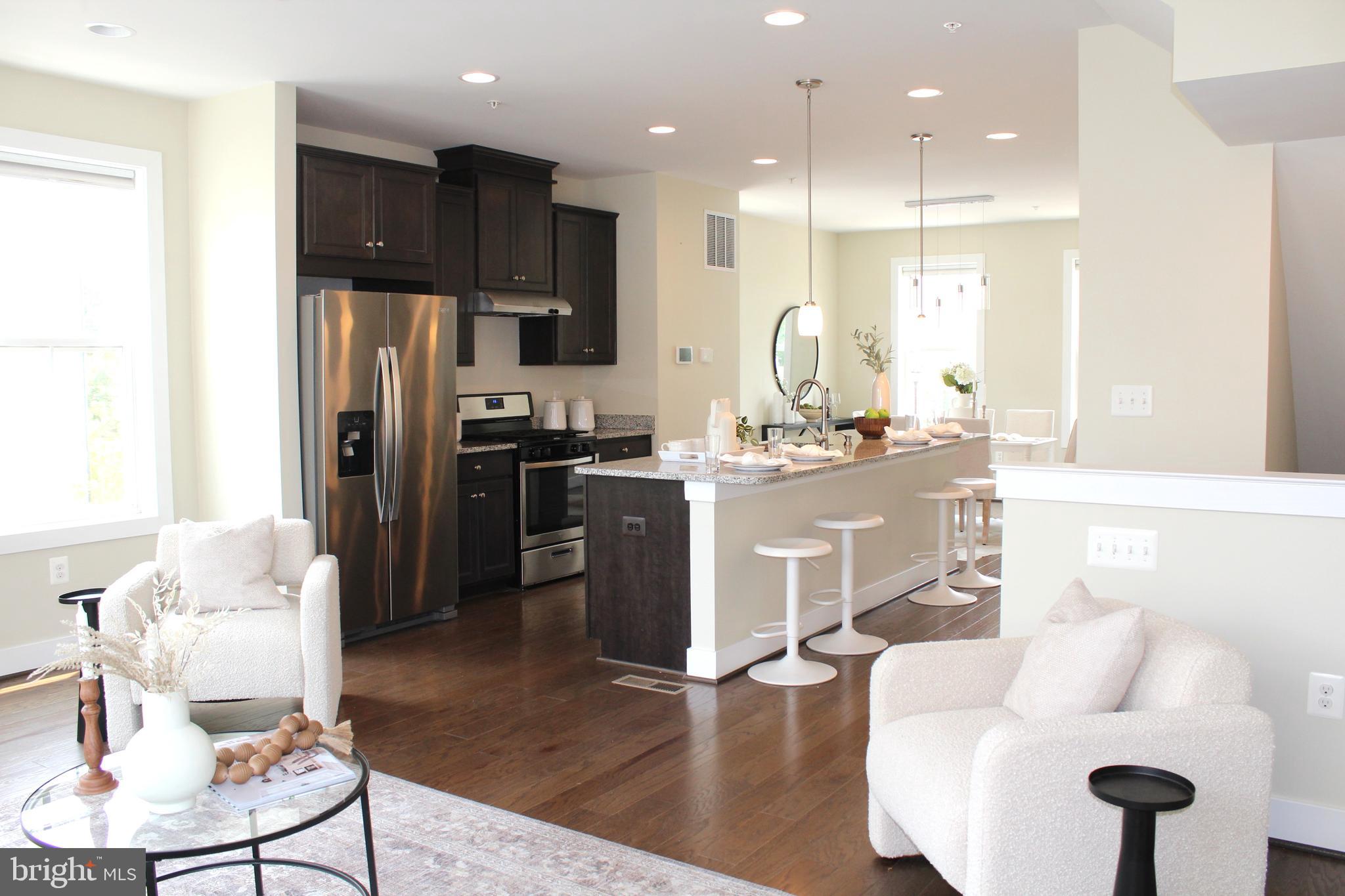 2411 Auden Drive Silver Spring, MD 20906 - Photo 14 of 45 a kitchen with stainless steel appliances kitchen island granite countertop a refrigerator a stove a sink a dining table and chairs with wooden floor