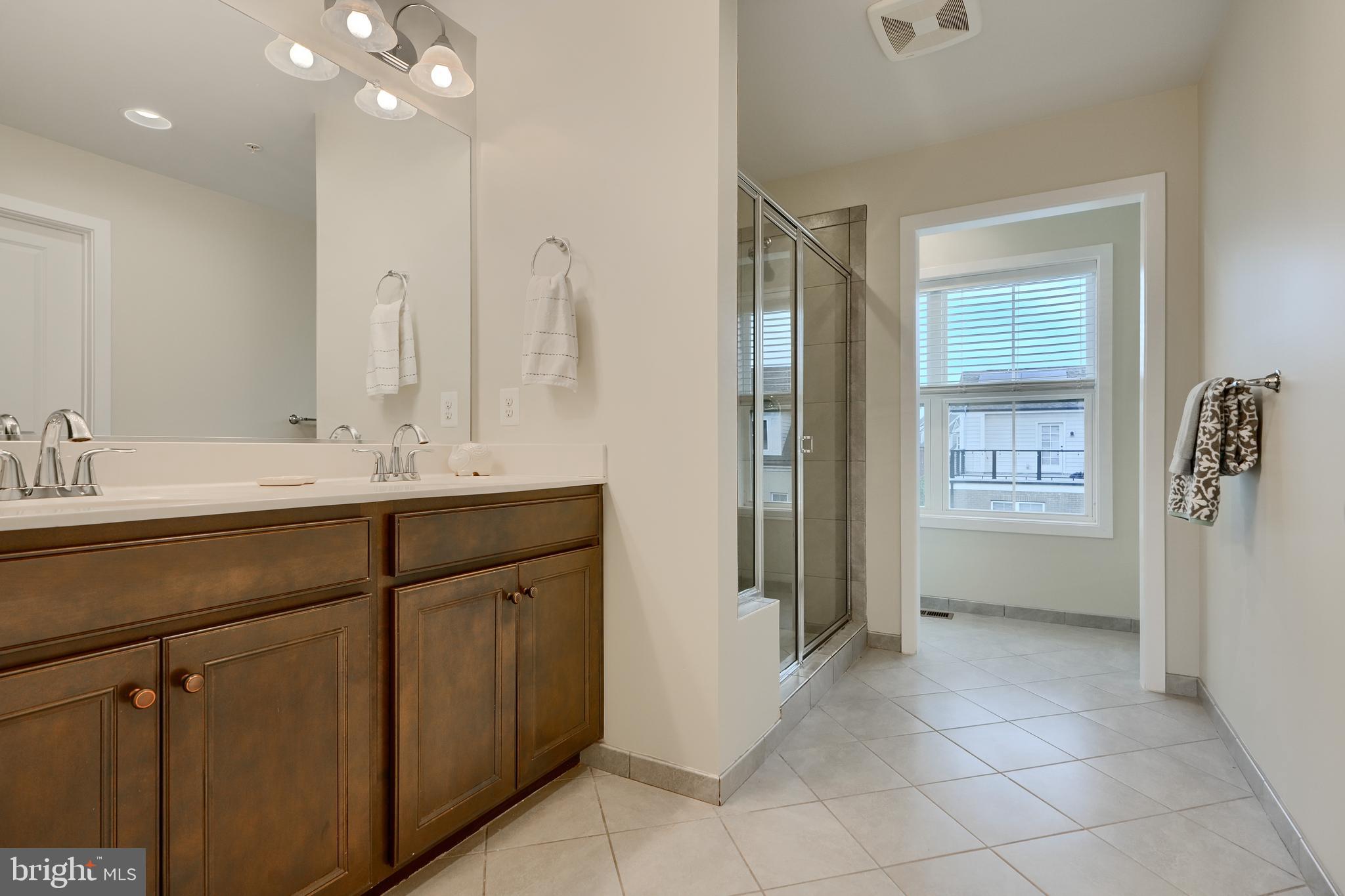 2411 Auden Drive Silver Spring, MD 20906 - Photo 24 of 45 a bathroom with a double vanity sink a mirror and a shower