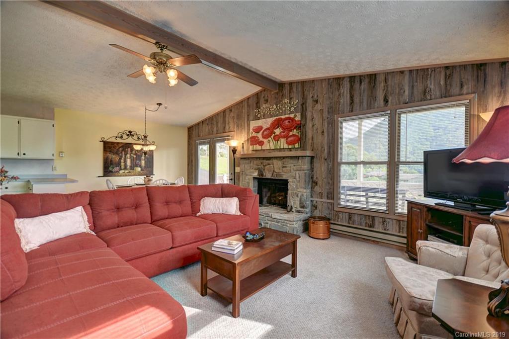 318 Stoney Ridge Loop Maggie Valley, NC 28751 - Photo 8 of 25 a living room with furniture a flat screen tv and a fireplace