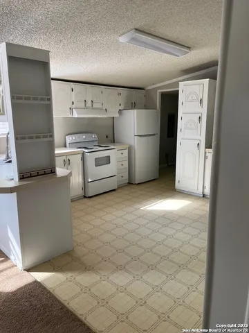 a kitchen with white cabinets and white appliances