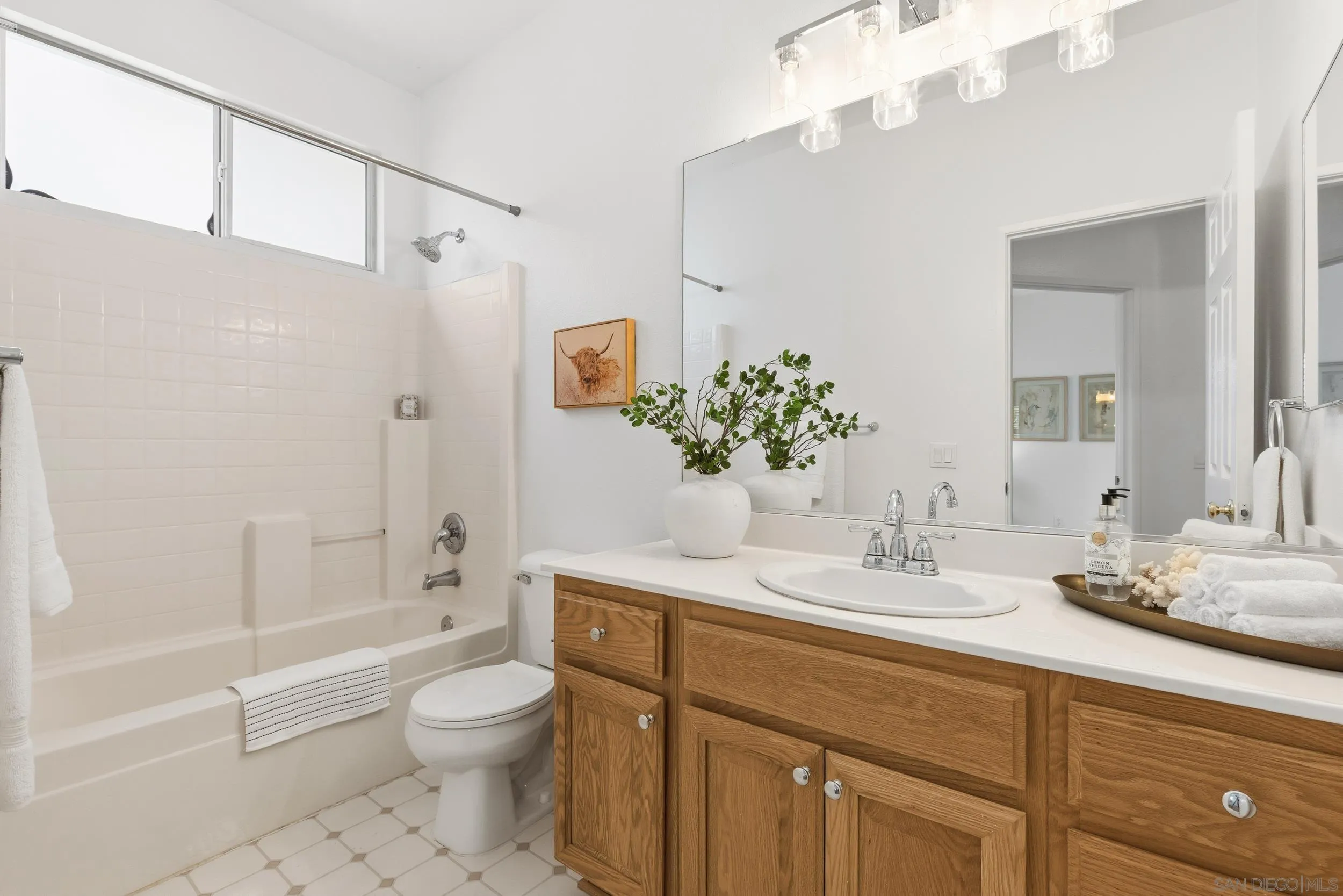 1126 Pacifica Place Encinitas, CA 92024 - Photo 12 of 18 a bathroom with a granite countertop sink toilet a large mirror a shower and bathtub