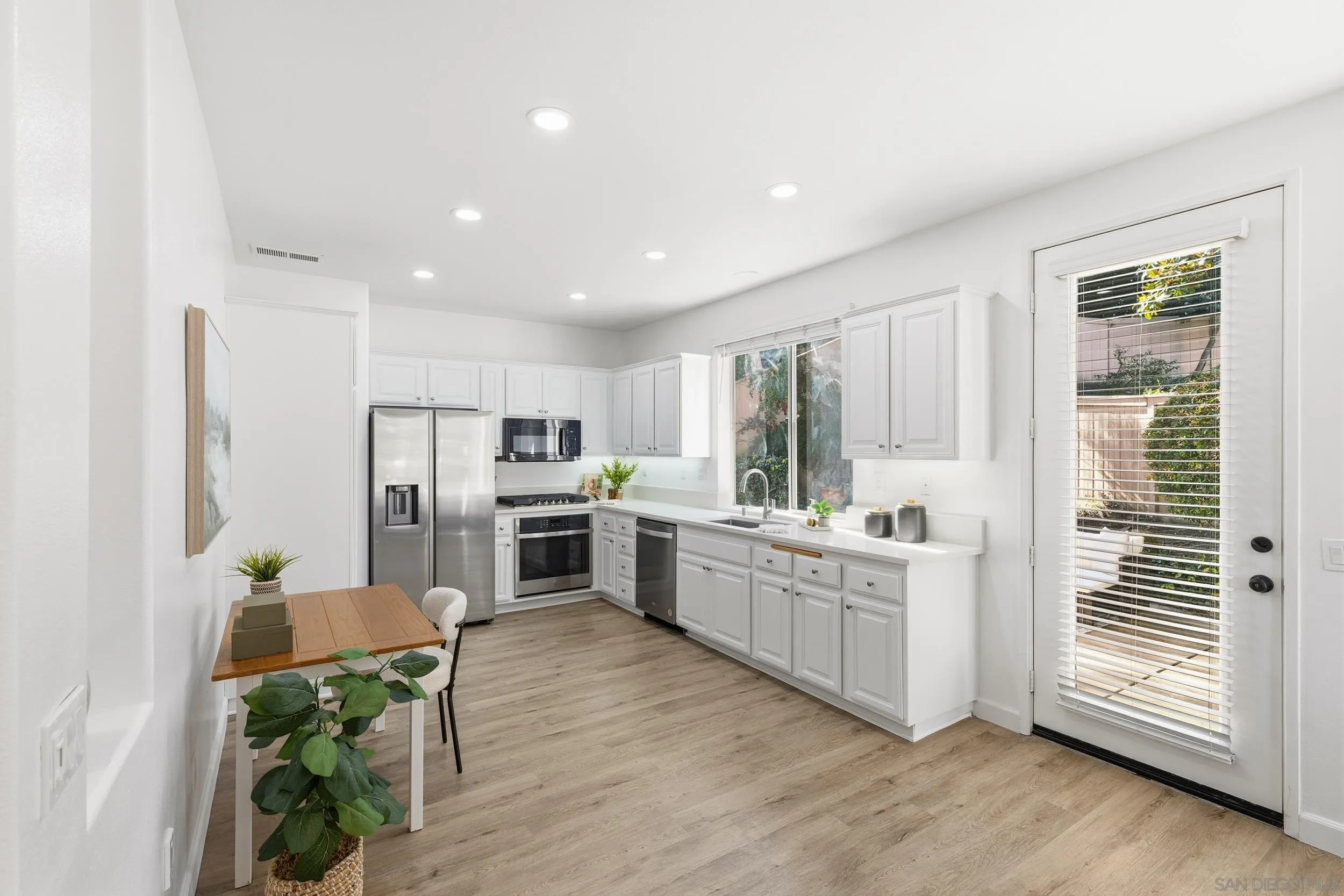 1126 Pacifica Place Encinitas, CA 92024 - Photo 5 of 18 a kitchen with white cabinets and stainless steel appliances