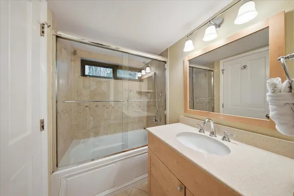 a bathroom with a granite countertop sink toilet a mirror and shower