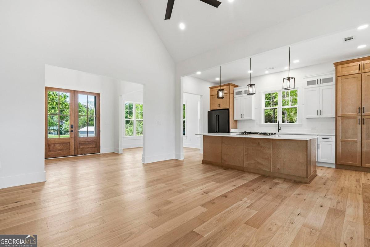 141 Grimes Road Northeast Milledgeville, GA 31061 - Photo 22 of 74 a large kitchen with stainless steel appliances a large counter top a wooden floor and a large window