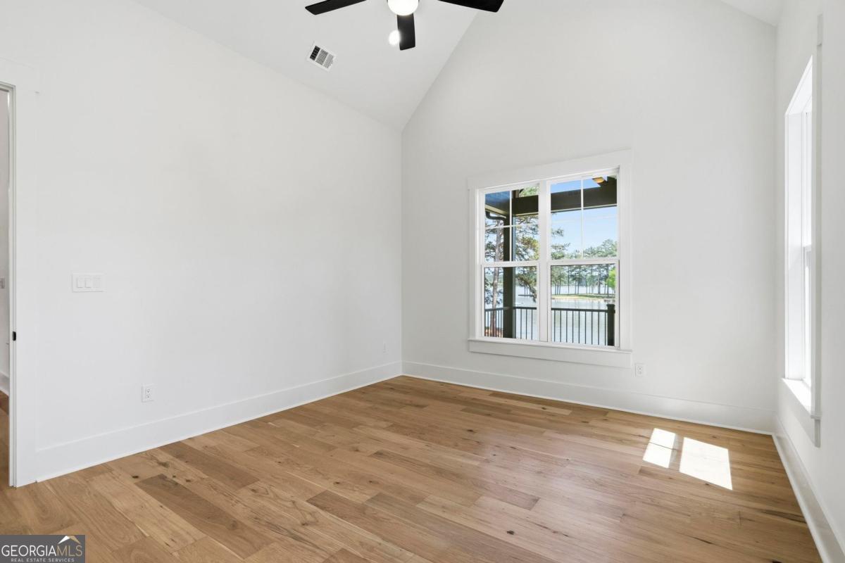141 Grimes Road Northeast Milledgeville, GA 31061 - Photo 28 of 74 an empty room with wooden floor and windows