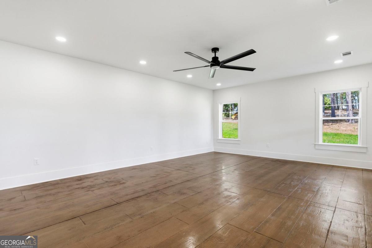 141 Grimes Road Northeast Milledgeville, GA 31061 - Photo 44 of 74 an empty room with windows and a ceiling fan