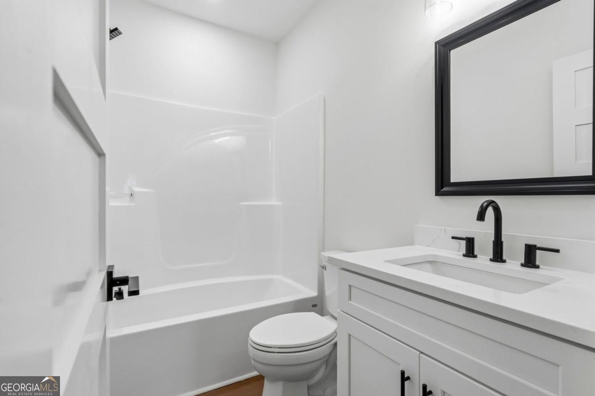 141 Grimes Road Northeast Milledgeville, GA 31061 - Photo 52 of 74 a bathroom with a sink a toilet and a large mirror
