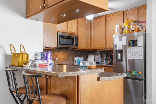 a kitchen with stainless steel appliances kitchen island granite countertop a refrigerator and microwave