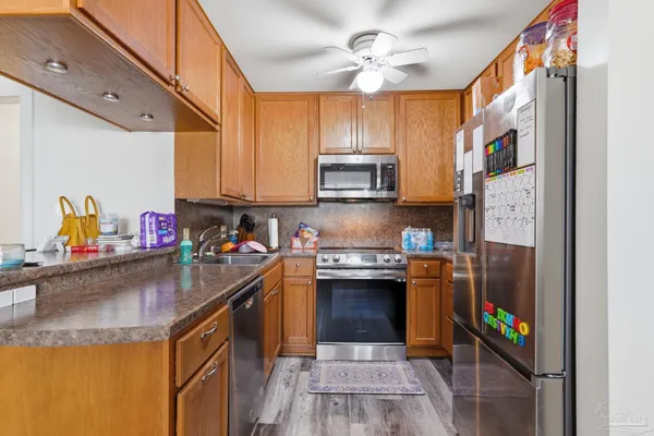 a kitchen with kitchen island granite countertop a sink cabinets and stainless steel appliances