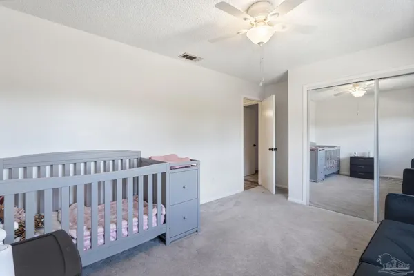 a view of a bedroom with furniture and chandelier fan