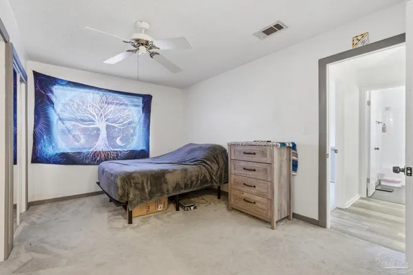 a spacious bedroom with a bed and a chandelier