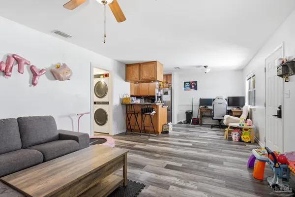 a living room with patio furniture and a wooden floor