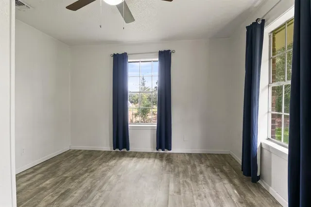 an empty room with window and wooden floor
