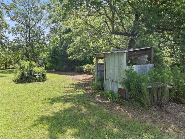 a backyard of a house with lots of plants and tree