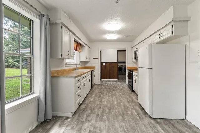 a kitchen with refrigerator cabinets and wooden floor