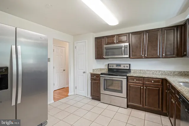 a kitchen with granite countertop a stove top oven and cabinets