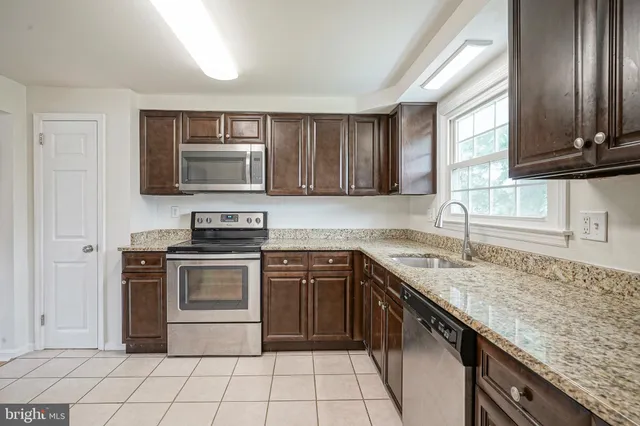 a kitchen with stainless steel appliances granite countertop a stove sink and microwave