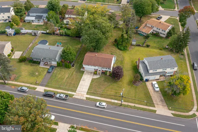 an aerial view of residential houses with outdoor space and parking