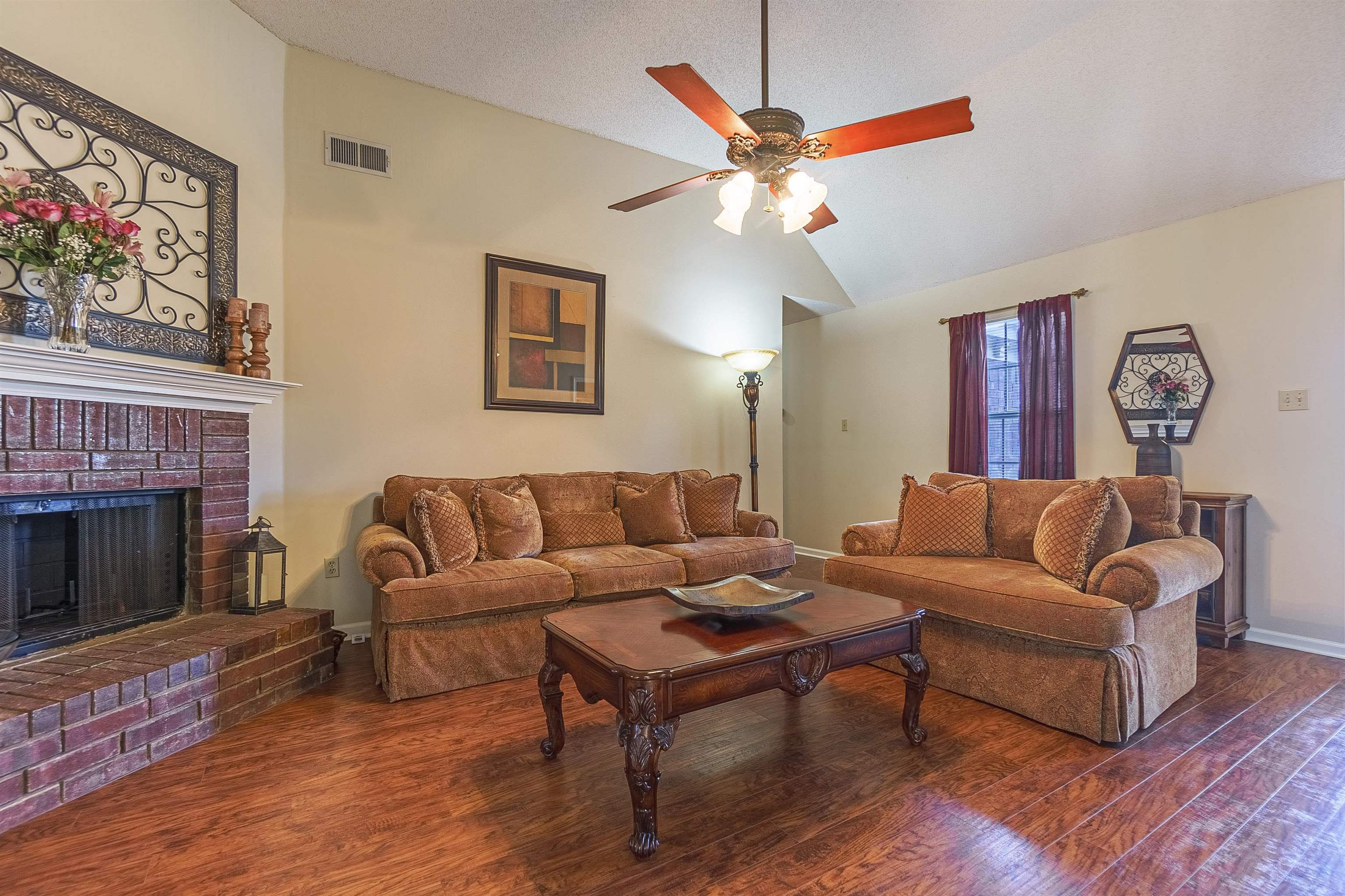 6419 Ragan Farm Drive Memphis, TN 38141 - Photo 5 of 27 Living room with a brick fireplace, vaulted ceiling, dark hardwood / wood-style floors, ceiling fan, and a textured ceiling