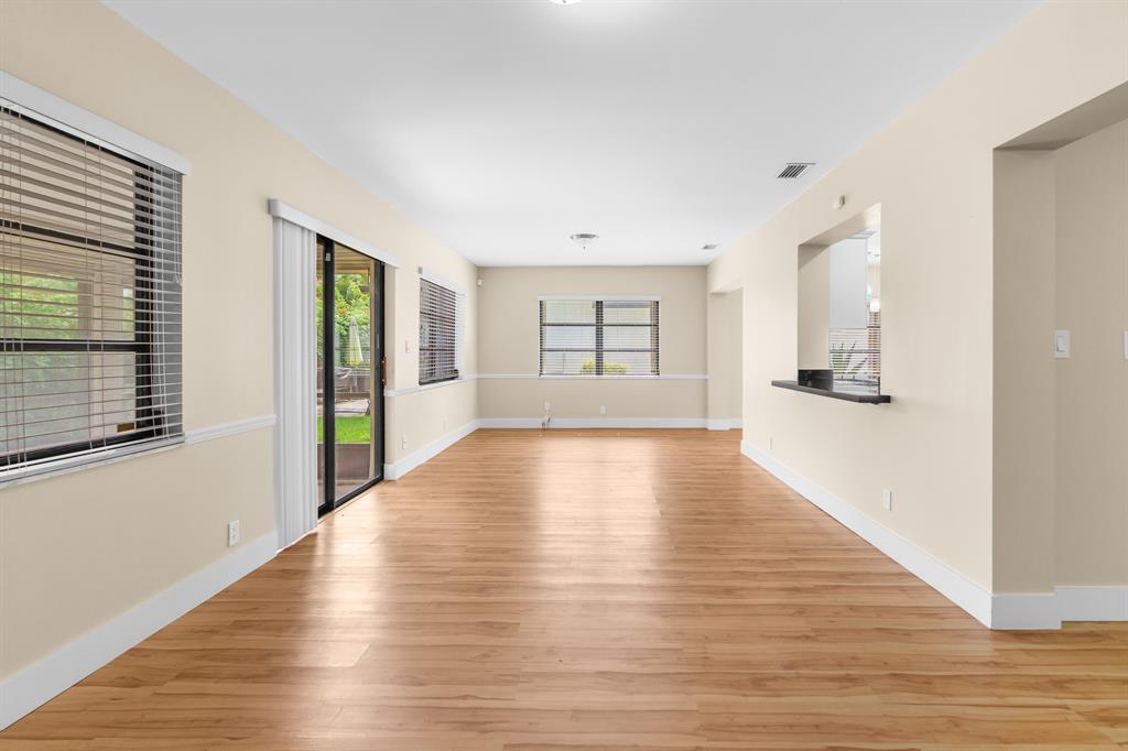 7836 Cloverfield Circle Boca Raton, FL 33433 - Photo 13 of 39 a view of an empty room with wooden floor and a window