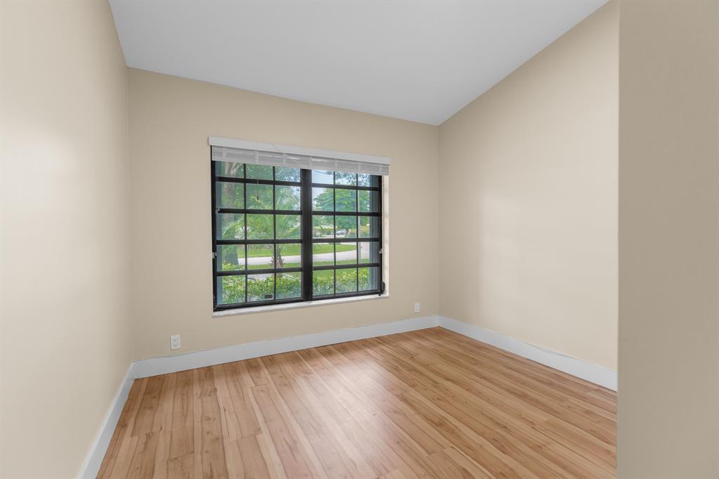 7836 Cloverfield Circle Boca Raton, FL 33433 - Photo 21 of 39 an empty room with wooden floor and windows