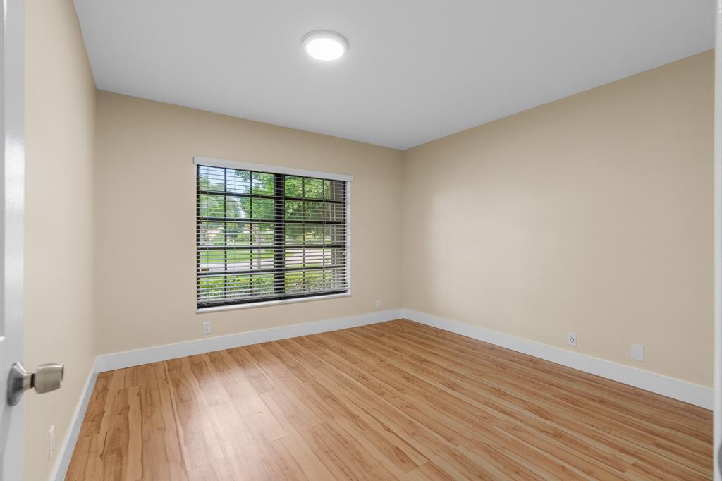 7836 Cloverfield Circle Boca Raton, FL 33433 - Photo 27 of 39 an empty room with wooden floor and windows